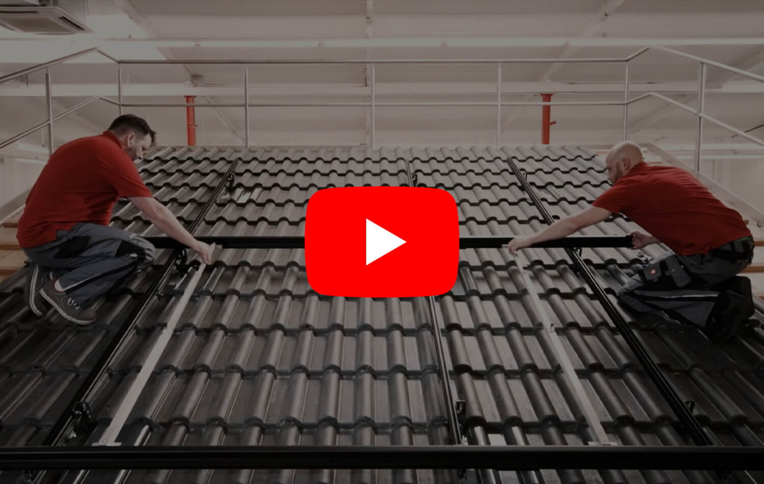 Zwei Monteure installieren ein Montagesystem auf einem Ziegeldach, Voransicht mit großem YouTube‑Play‑Button