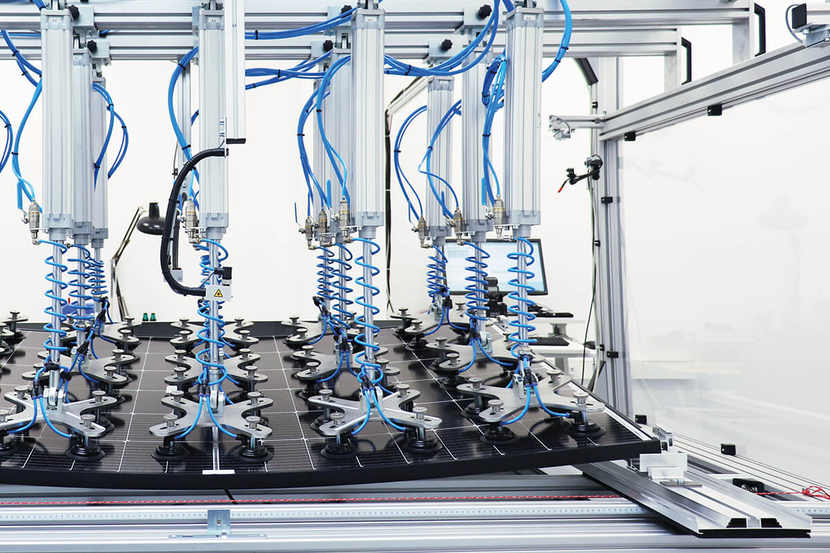 Automatisierte Prüfanlage mit mehreren Pneumatikarmen und Saugnäpfen, die ein Solarmodul für Qualitätstests fixieren